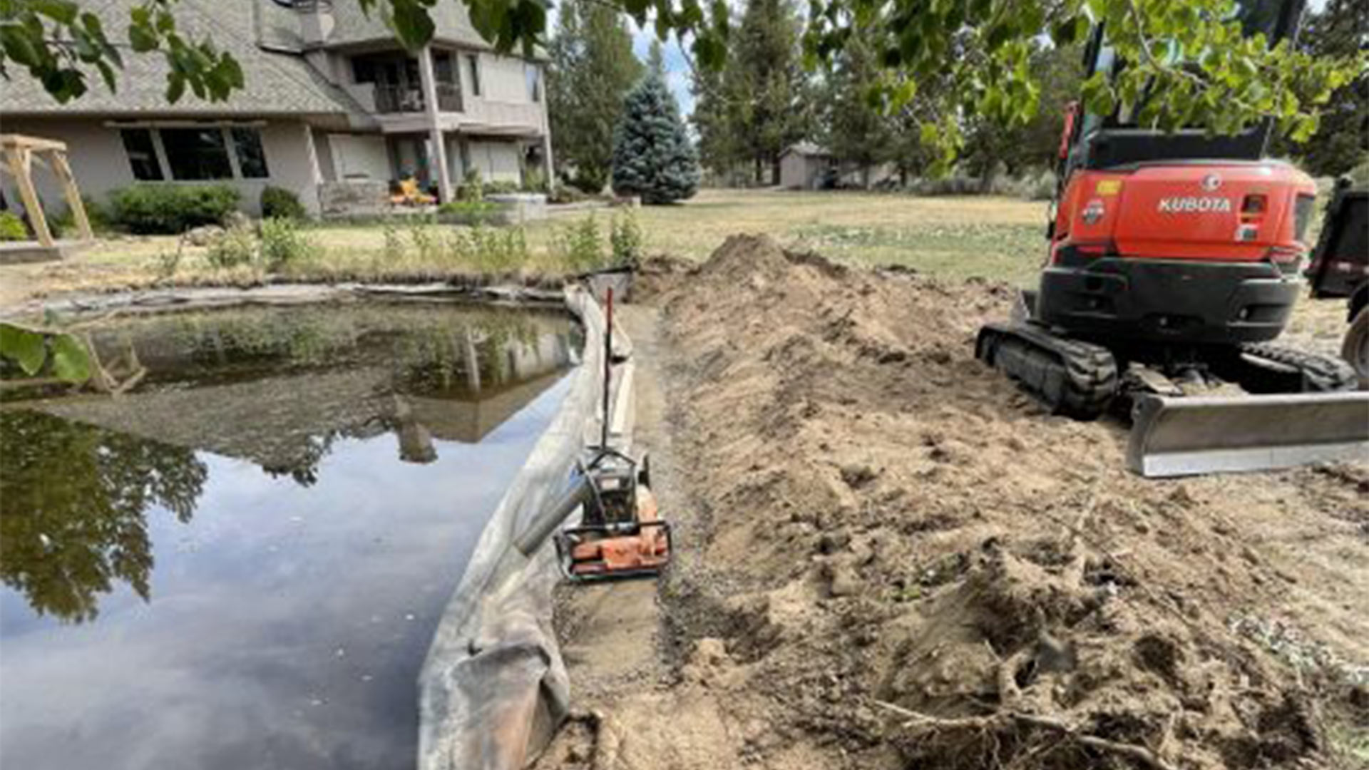 machines working on landscaping near pond bend or
