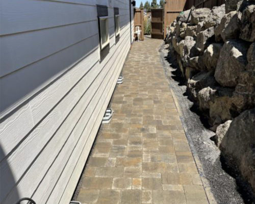 paved concrete pathway on the side of house bend or